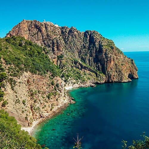 The cliffs of Cap Carbon in Béjaïa above clear turquoise water